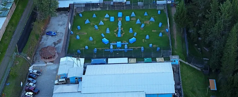 Vista aérea de la sede matriz en Iñaquito Alto: canchas, galpones y parqueadero rodeados de bosque
