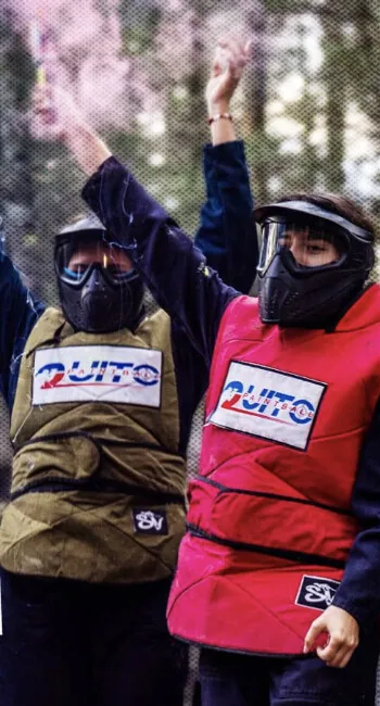 Grupo de una empresa en plena partida, entre humo de colores, con equipo completo de protección