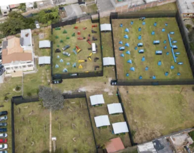 Vista aérea de la sede Puembo con sus canchas cercadas, las carpas y el parqueadero